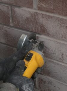 Masonry requires expertise and a steady hand, as shown here with a crew member using a grinder on brick.