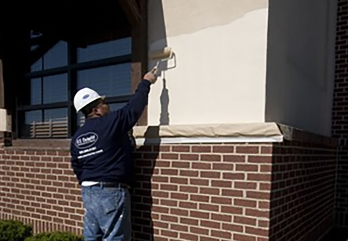 US Exterior crew re-coating the exterior of a commercial building