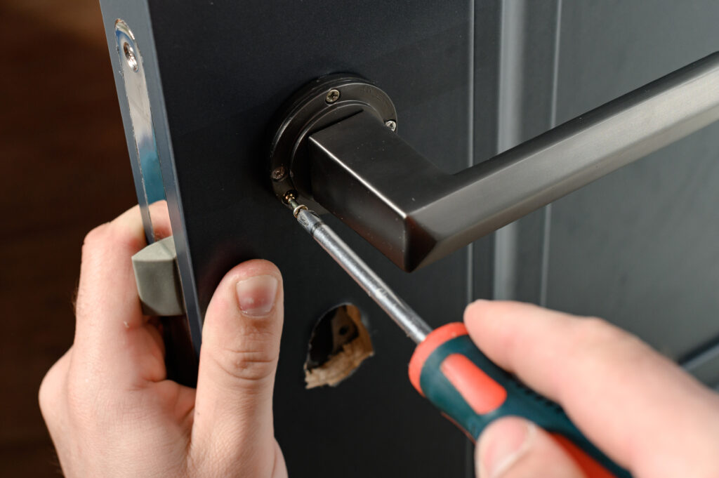 Installation of a door handle on interior doors, carpentry work with doors, metal door handle.